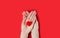 Females hands holds red heart on red background. Close-up. Top view. Place for text