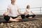 Females in lotus asana smiling in meditation under sunlight