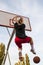 Females playing basketball on street court. Woman streetball player making slam dunk in a basketball game.