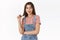 Feminine alluring young caucasian woman in overalls, t-shirt silly rolling hair strand on finger and looking right with