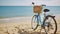 Feminine bicycle of comfort class with empty basket on the sandy beach of mediterranean sea. Blue cruiser bike on sunny day at sea
