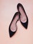 Feminine black suede shoese  on peach color background