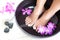 Feminine feet in foot spa bowl