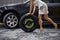 Feminine yet handy. Cropped image of a young woman wheeling a tyre.