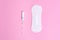 Feminine hygiene products. Tampon and daily panty liner on a pink background. Choice concept