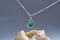 Feminine pendant with chain made of silver and turquoise epoxy resin inside with a seashell isolated over gradient