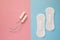 Feminine sanitary pad and tampon on a pink background. The concept of feminine hygiene during menstruation. Flat lay, top view