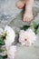 Feminine styled stock photo. Vertical composition. White and pink peony flowers on grunge concrete floor. Defocused kids