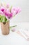 Feminine workspace. Bright and airy desk top with notepad and flowers. Vertical