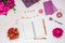 Feminine workspace with open notebook, good morning lettering on wooden blocks, strawberries, pink peonies flowers, cosmetic