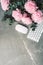 Feminine workspace. White computer keyboard, mouse, peony flowers, eucalyptus flowers on marble background. Top view. Copy space.