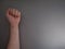 Feminism. Female fist on a gray background. Top view, minimalism