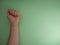 Feminism. Female fist on a green background. Top view, minimalism