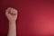 Feminism. Female fist on a red background. Top view, minimalism