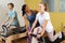 Femle instructor helps and monitors the difficulty of Pilates exercise for an girl