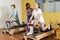 Femle instructor helps and monitors the difficulty of Pilates exercise for an girl