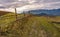 Fence along dirt road in mountainous rural area