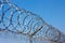 Fence with barbed wire against the blue sky. Symbol of freedom of imprisonment