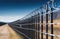 A fence with barbed wire in a field, receding perspective. Fencing at a secret facility