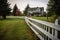 a fence circling a secluded home in a rural setting