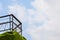 Fence on a cliff steep with cloud in blue sky