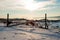 Fence in frozen fjord in winter sunshine, Norway