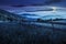 Fence on hillside meadow in mountains at night