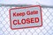 Fence with Keep Gate Closed sign against snow