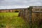 Fence line on a cloudy autumn day. Old wood and barbed wire tall weeds