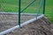 Fence with a lower part which is made of concrete slabs as protection against game. undercutting the fence may occur. now the hous