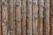 A fence made from brown round vertical pine logs. Natural log background