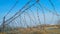 A fence made of coils of steel barbed wire against a blue sky