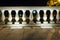 Fence, marble pillars with illuminated lanterns. Evening