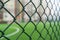 Fence netting close-up on a background of a soccer field.