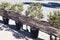 A fence of olive trees in vases and reed branches on the streets of a European city. Street decor