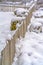 Fence and shrubbery on snow covered ground