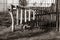 On  fence stands a self-carved wind chime made of wood