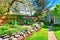 Fenced backyard with green lawn and patio area. View of the blue shed.