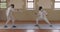 Fencer athletes during a fencing training in a gym