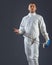 Fencing athlete posing with a sword or epee on gray background