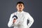 Fencing athlete posing with a sword or epee on gray background