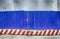 Fencing of construction site with red construction light on the background of blue profiled sheet fence