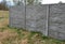 Fencing with a gray panel fence in the garden with a lawn and concrete interlocking paving. A panel fence is the best protection a