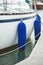 Fenders suspended between a boat and dockside for protection. Maritime fenders