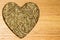 Fennel dill seeds heart shaped on wooden board