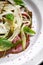 Fennel salad with beef carpaccio, Basil and pesto on a white plate