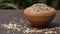 Fennel seeds in a small clay bowl on an old wooden table./ Fennel seeds over white background.