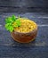 Fenugreek with leaf in clay bowl on wooden board