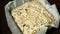 Fermentation fresh yeast dough bread with hazelnuts, pumpkin seeds and sunflower seeds on baking paper in a metal pan.