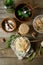 Fermented cabbage, cucumbers, salt, spices on wooden background, top view